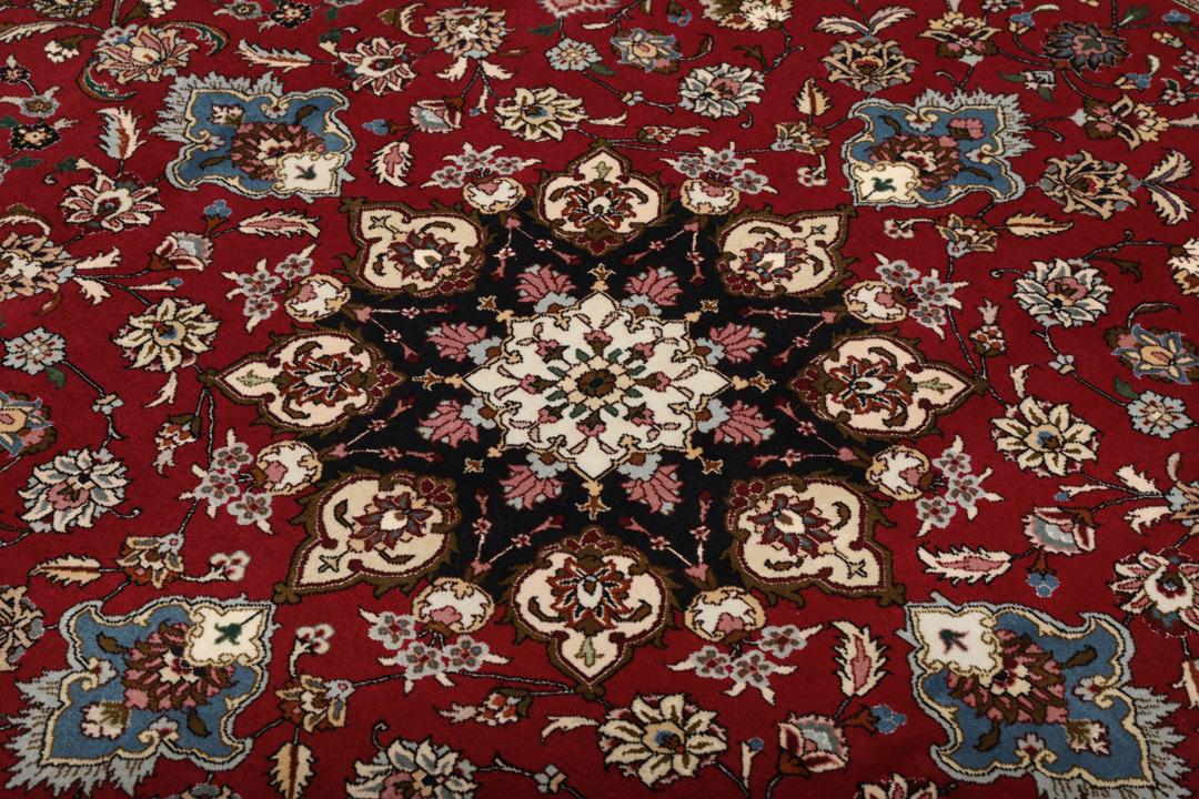 Een vierkant handgeknoopt Tabriz tapijt met een rood veld en een centraal medaillon uit het Midden-Oosten