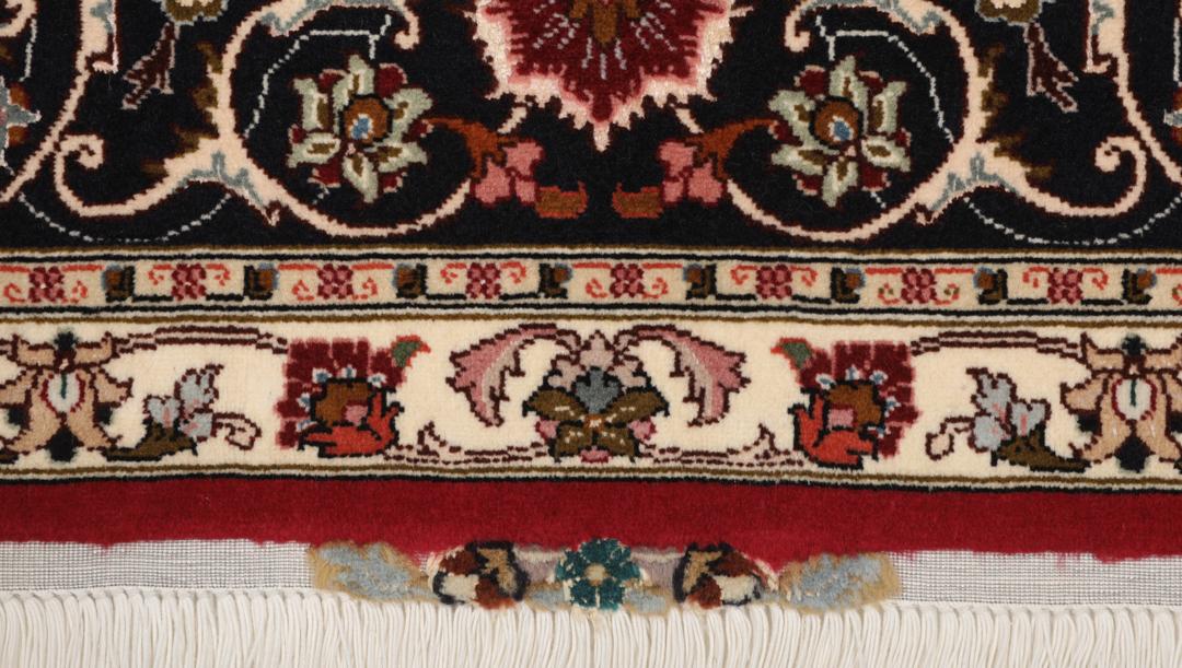 Een vierkant handgeknoopt Tabriz tapijt met een rood veld en een centraal medaillon uit het Midden-Oosten