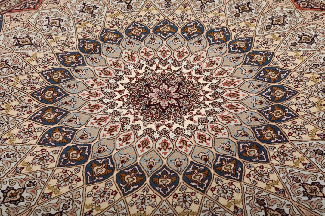 Een vierkant Tabriz-tapijt met een gedetailleerd centraal medaillon in beige en blauwe tinten uit het Midden-Oosten.