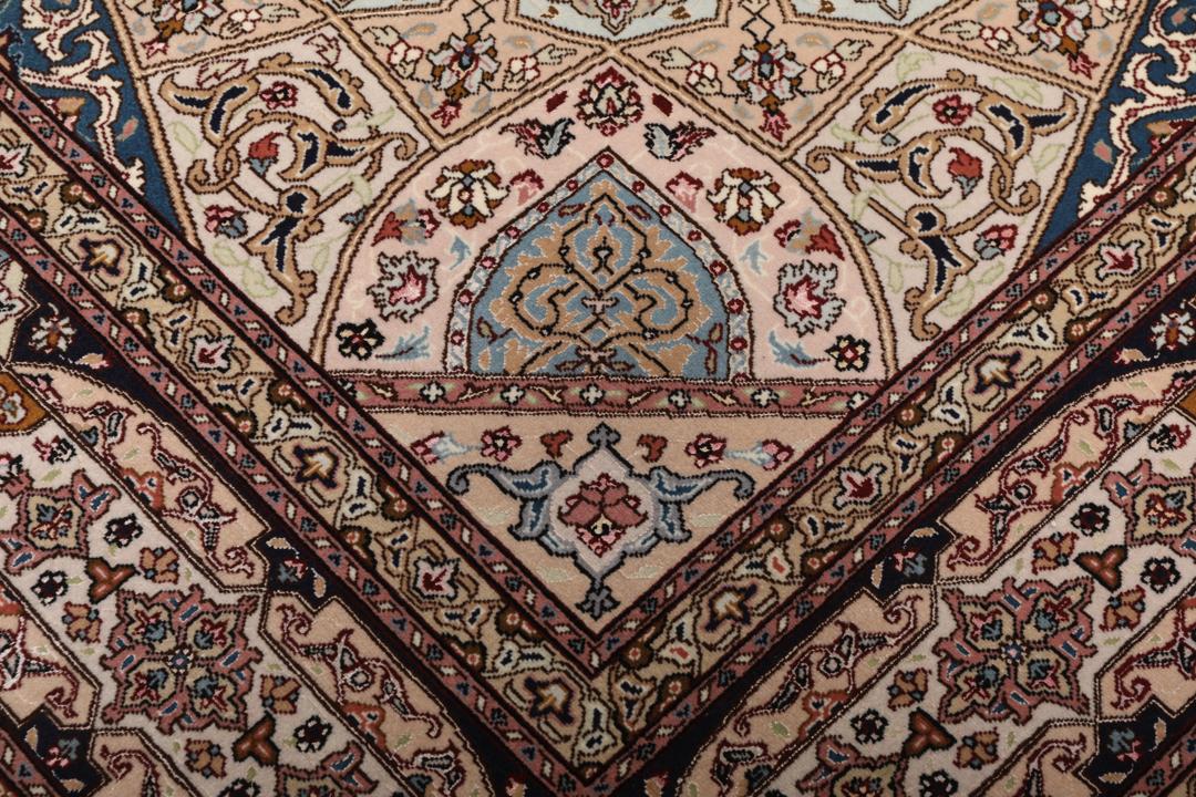Een vierkant Tabriz-tapijt met een gedetailleerd centraal medaillon in beige en blauwe tinten uit het Midden-Oosten.