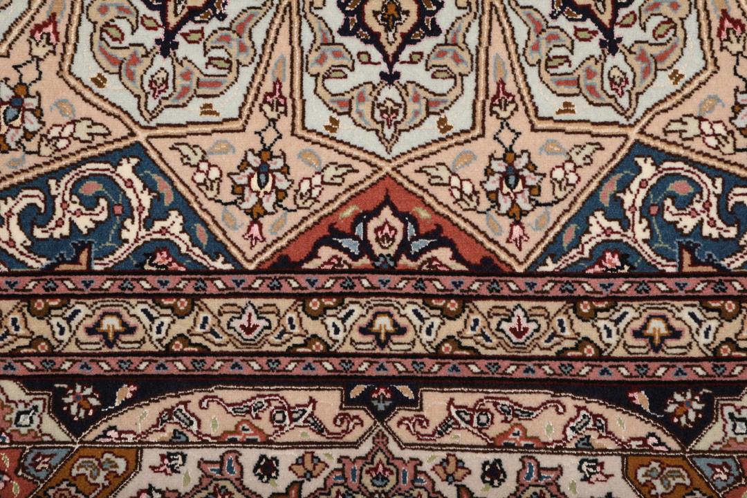 Een vierkant Tabriz-tapijt met een gedetailleerd centraal medaillon in beige en blauwe tinten uit het Midden-Oosten.