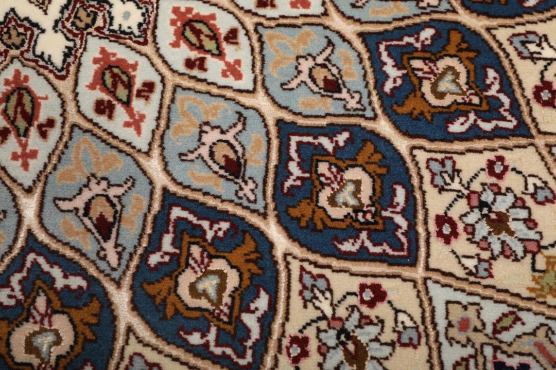 Een vierkant Tabriz-tapijt met een gedetailleerd centraal medaillon in beige en blauwe tinten uit het Midden-Oosten.