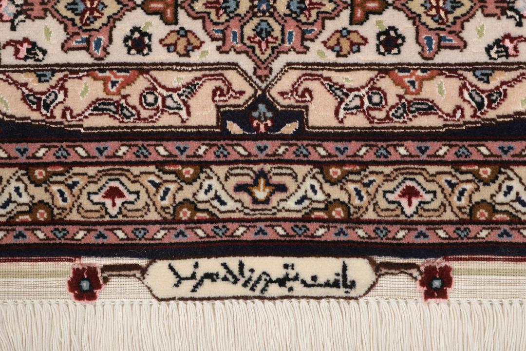 Een vierkant Tabriz-tapijt met een gedetailleerd centraal medaillon in beige en blauwe tinten uit het Midden-Oosten.