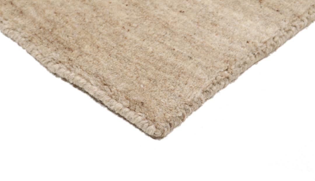 A rectangular rug in natural white and beige with a simple border design.