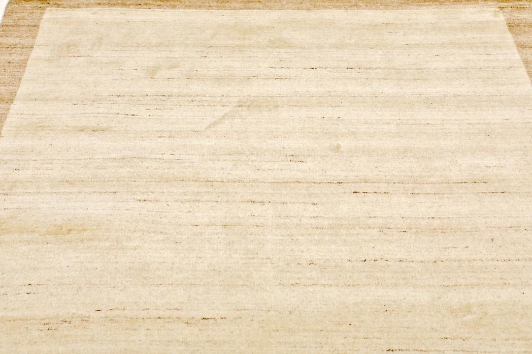 A rectangular rug in natural white and beige with a simple border design.