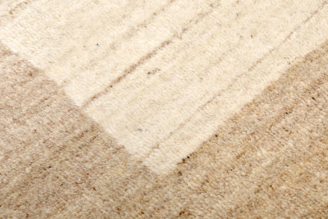 A rectangular rug in natural white and beige with a simple border design.