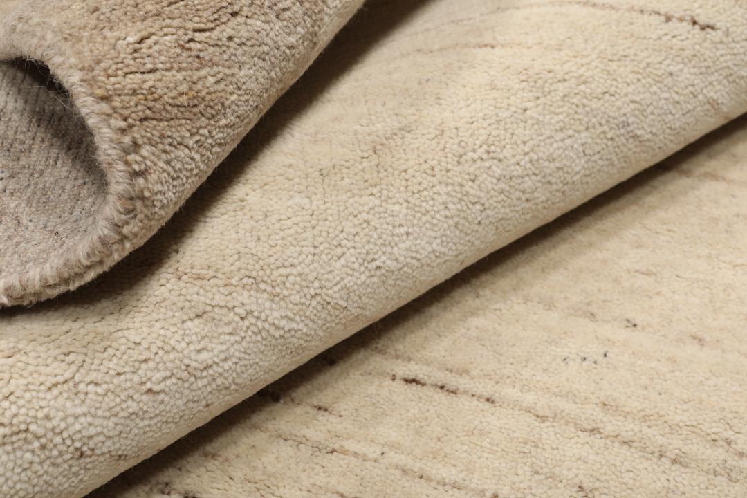 A rectangular rug in natural white and beige with a simple border design.