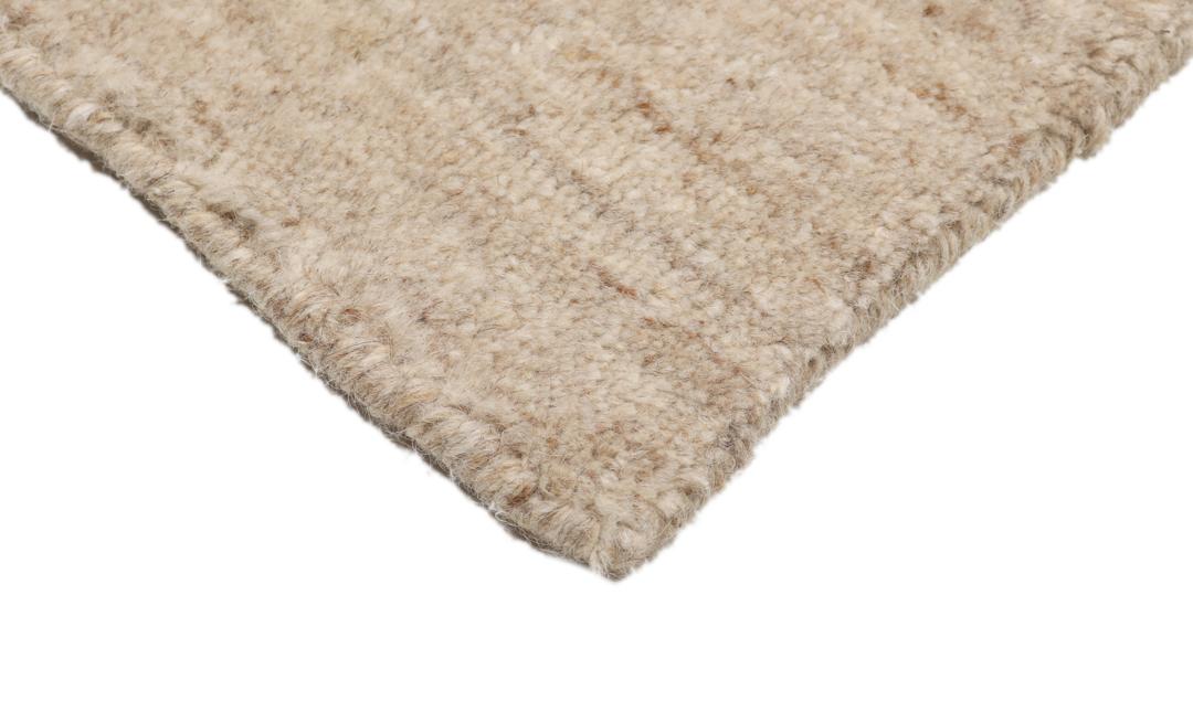 Et rektangulært tæppe i naturhvid og beige med et enkelt kantdesign.