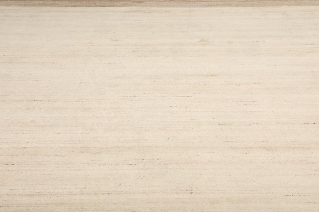 Et rektangulært tæppe i naturhvid og beige med et enkelt kantdesign.