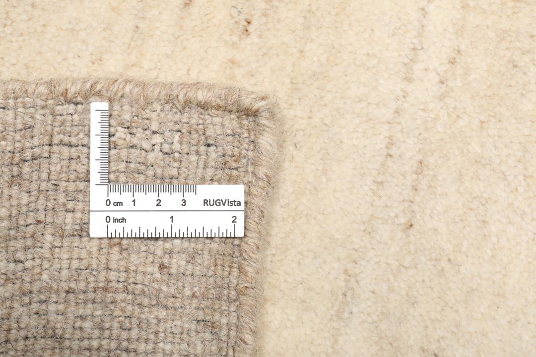 Et rektangulært tæppe i naturhvid og beige med et enkelt kantdesign.