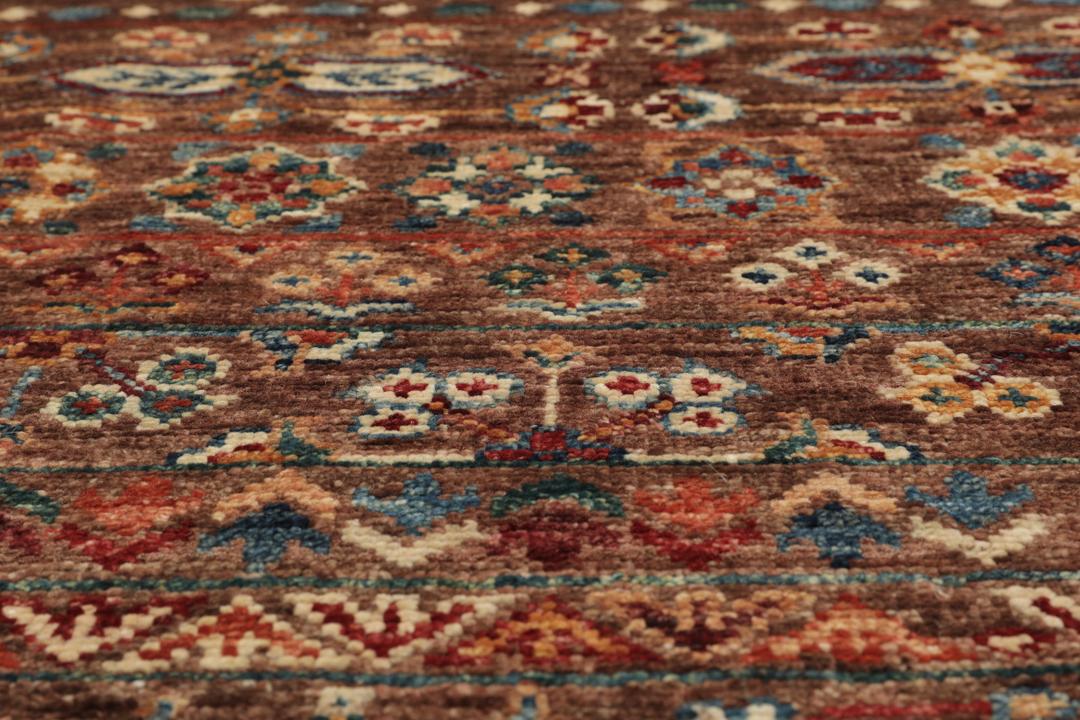 Una alfombra marrón anudada a mano única de Afganistán con intrincados patrones geométricos y florales.