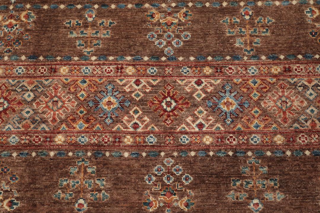 Una alfombra marrón anudada a mano única de Afganistán con intrincados patrones geométricos y florales.