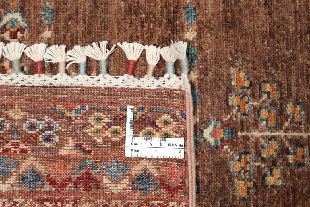 Una alfombra marrón anudada a mano única de Afganistán con intrincados patrones geométricos y florales.