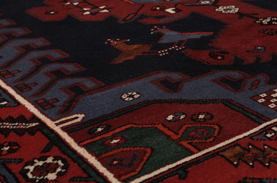 Een handgeknoopte Hamadan loper met een donkerblauw en rood geometrisch patroon.