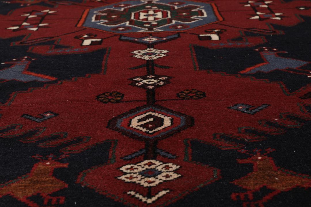 Een handgeknoopte Hamadan loper met een donkerblauw en rood geometrisch patroon.