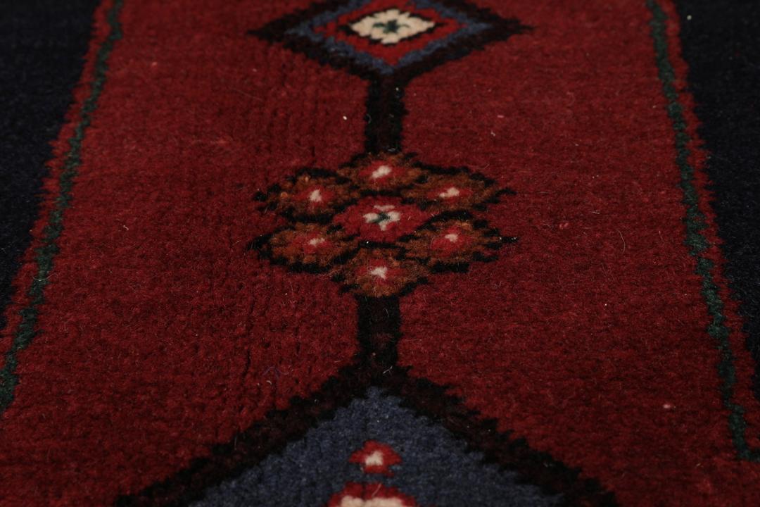 Een handgeknoopte Hamadan loper met een donkerblauw en rood geometrisch patroon.