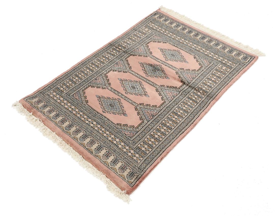 A rectangular Pakistan Bokhara rug with pink field and geometric medallion motifs