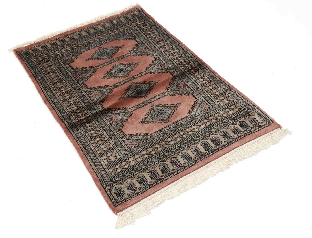 A rectangular Pakistan Bokhara rug with pink field and geometric medallion motifs