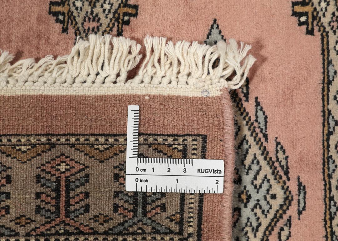A rectangular Pakistan Bokhara rug with pink field and geometric medallion motifs