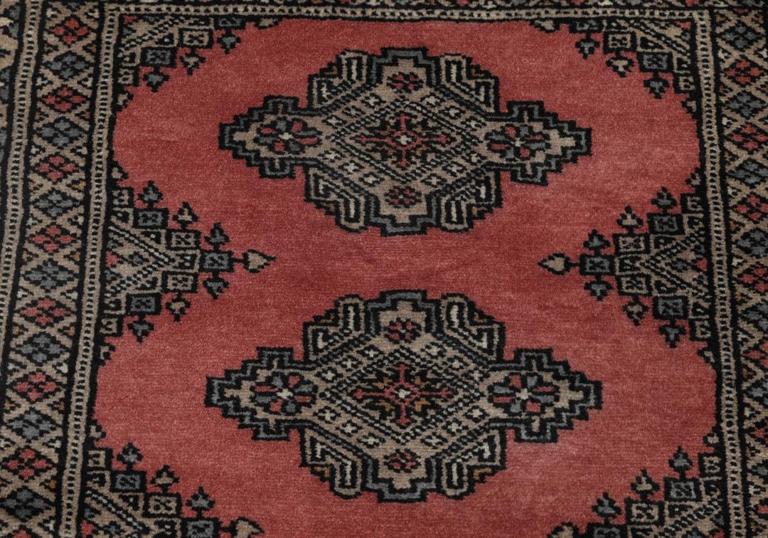 Hand-knotted Pakistan Bokhara rug with a red and beige geometric pattern