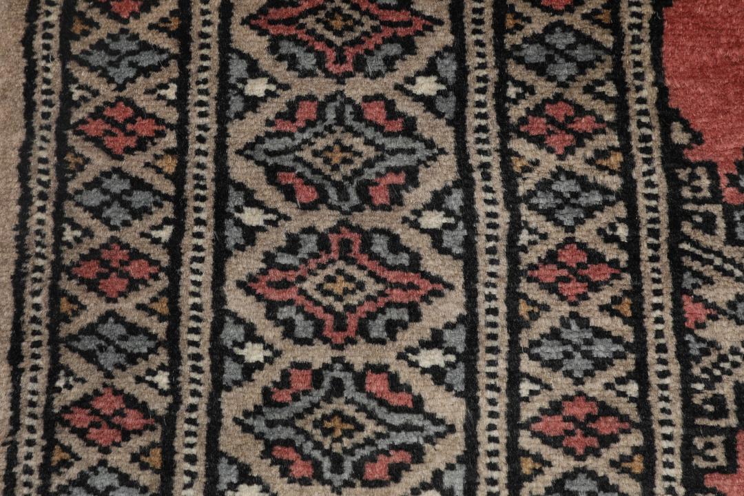 Hand-knotted Pakistan Bokhara rug with a red and beige geometric pattern