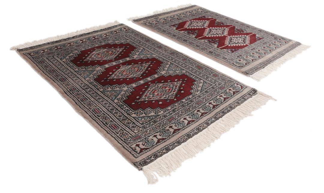 A rectangular hand-knotted Pakistan Bokhara rug with a deep red field and geometric motifs.