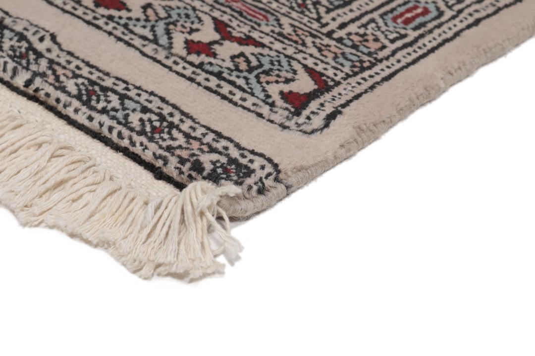 A rectangular hand-knotted Pakistan Bokhara rug with a deep red field and geometric motifs.