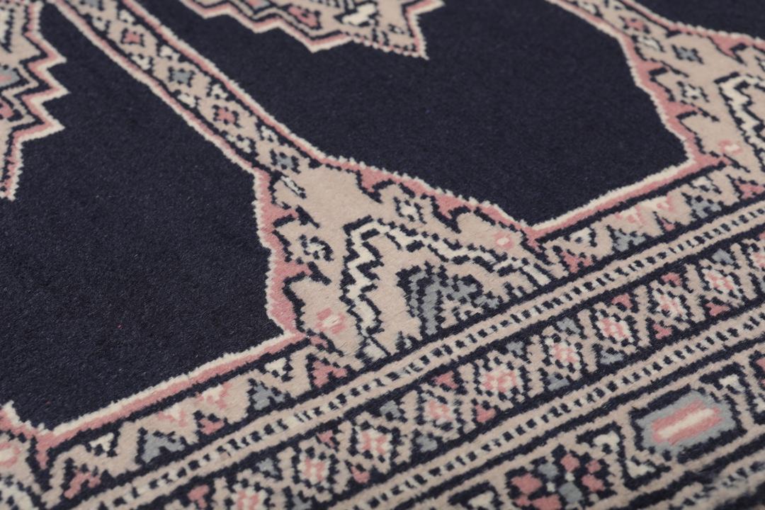Hand-knotted rug from Pakistan with dark-blue and pink detailing