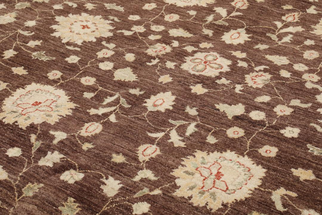 A hand-knotted Afghan rug with a dark brown field and ornate floral patterns.