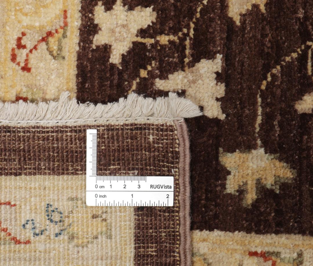 A hand-knotted Afghan rug with a dark brown field and ornate floral patterns.