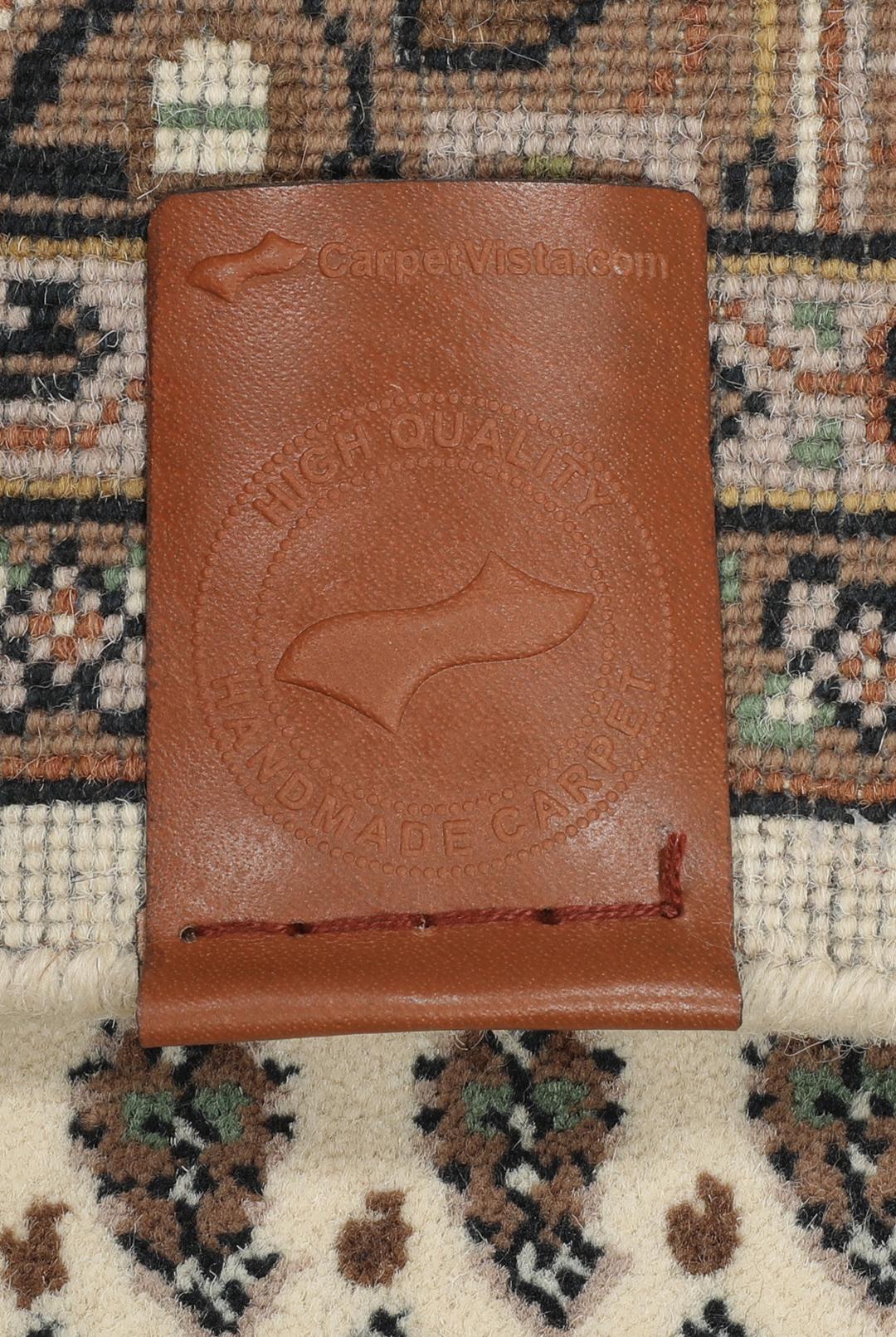 Een handgeknoopt Mir Indo-tapijt uit India met een beige veld en aardse bruine randen.