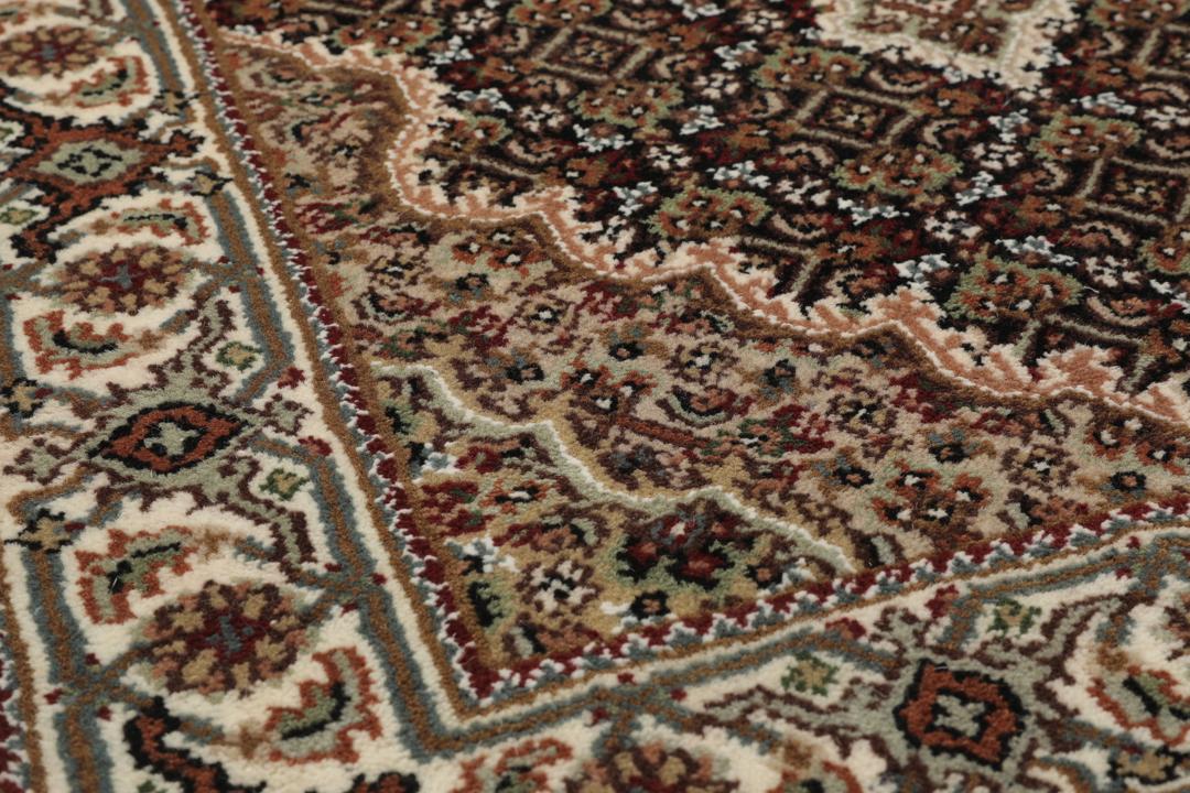 En håndknyttet brun Tabriz-løber med ornamenterede medaljonmønstre.