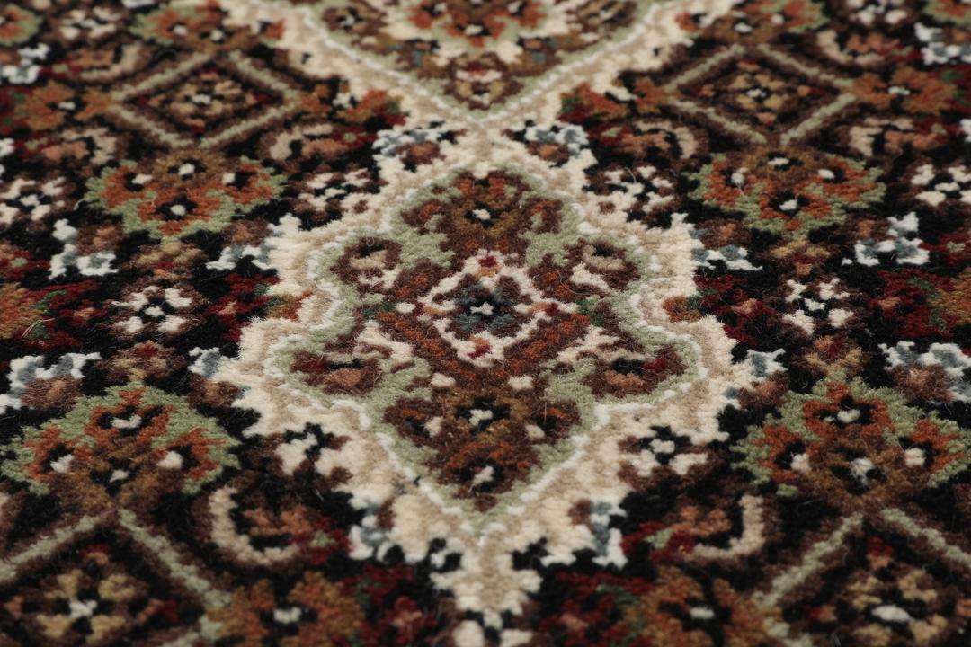 En håndknyttet brun Tabriz-løber med ornamenterede medaljonmønstre.