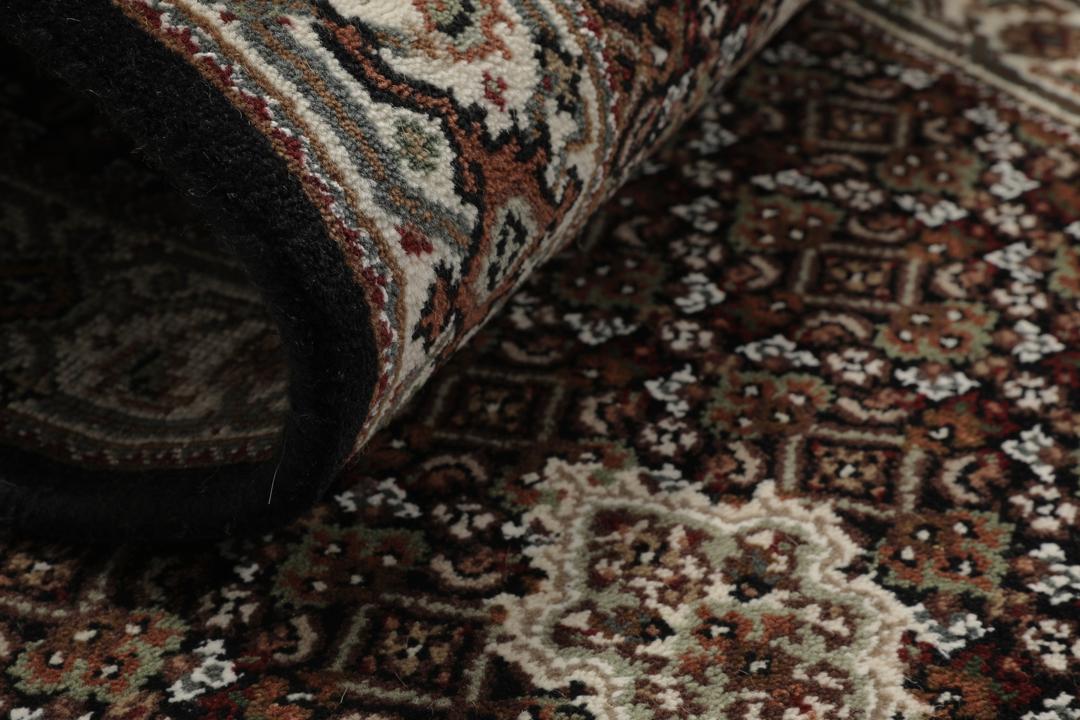 En håndknyttet brun Tabriz-løber med ornamenterede medaljonmønstre.