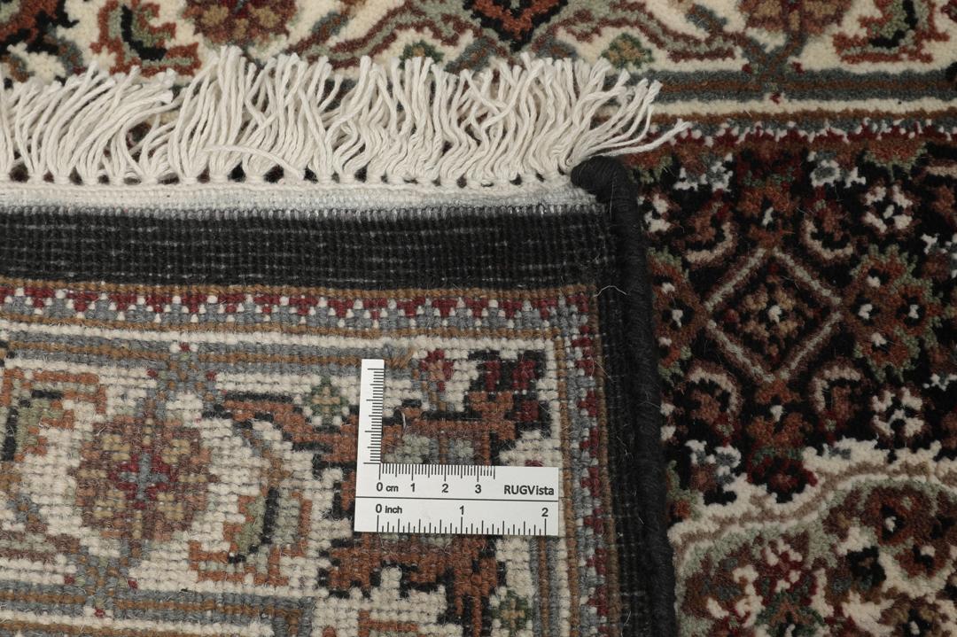 En håndknyttet brun Tabriz-løber med ornamenterede medaljonmønstre.