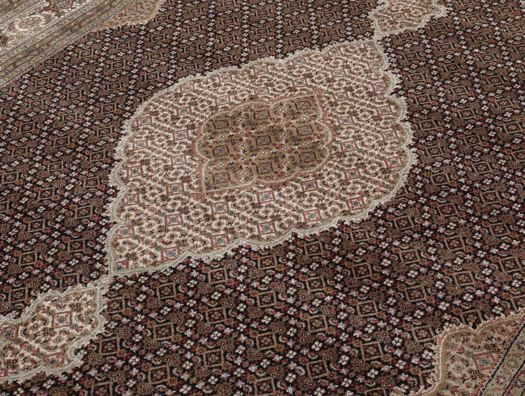 Et stort rektangulært Tabriz-tæppe med et medaljondesign i brune og beige nuancer, med oprindelse fra Indien.