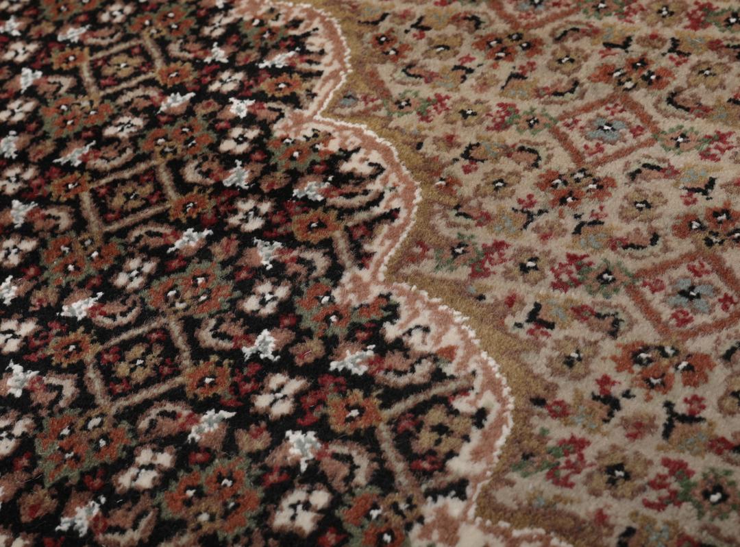 Et stort rektangulært Tabriz-tæppe med et medaljondesign i brune og beige nuancer, med oprindelse fra Indien.