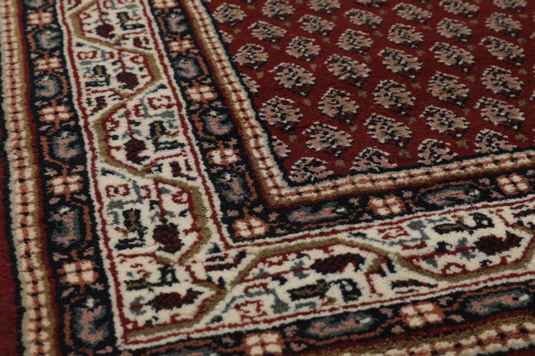 Een handgeknoopt Mir Indo tapijt uit India in diepe donkerrode tinten.