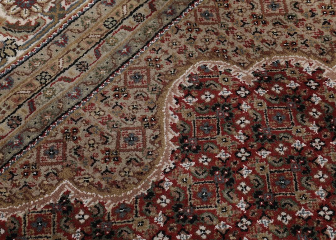 Duży prostokątny dywan typu Tabriz z Indii z centralnym medalionem w kolorze czerwonym i beżowym.