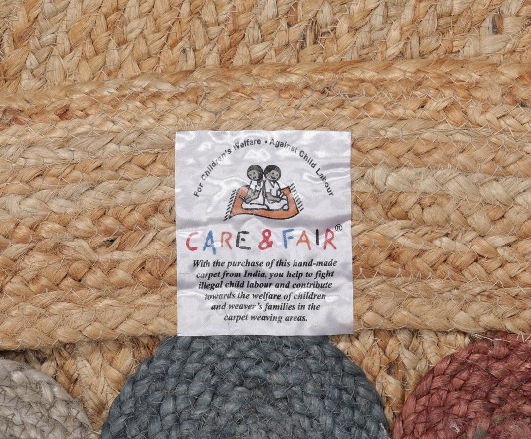 Rond meerkleurig tapijt gemaakt van natuurlijk jute met een decoratieve rand