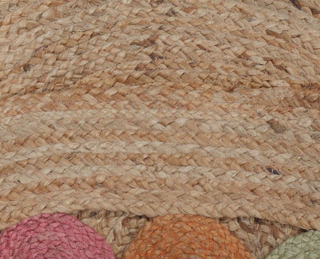 Rond meerkleurig tapijt gemaakt van natuurlijk jute met een decoratieve rand