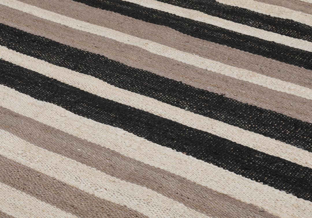 Beige og svart stripete teppe laget av jute.
