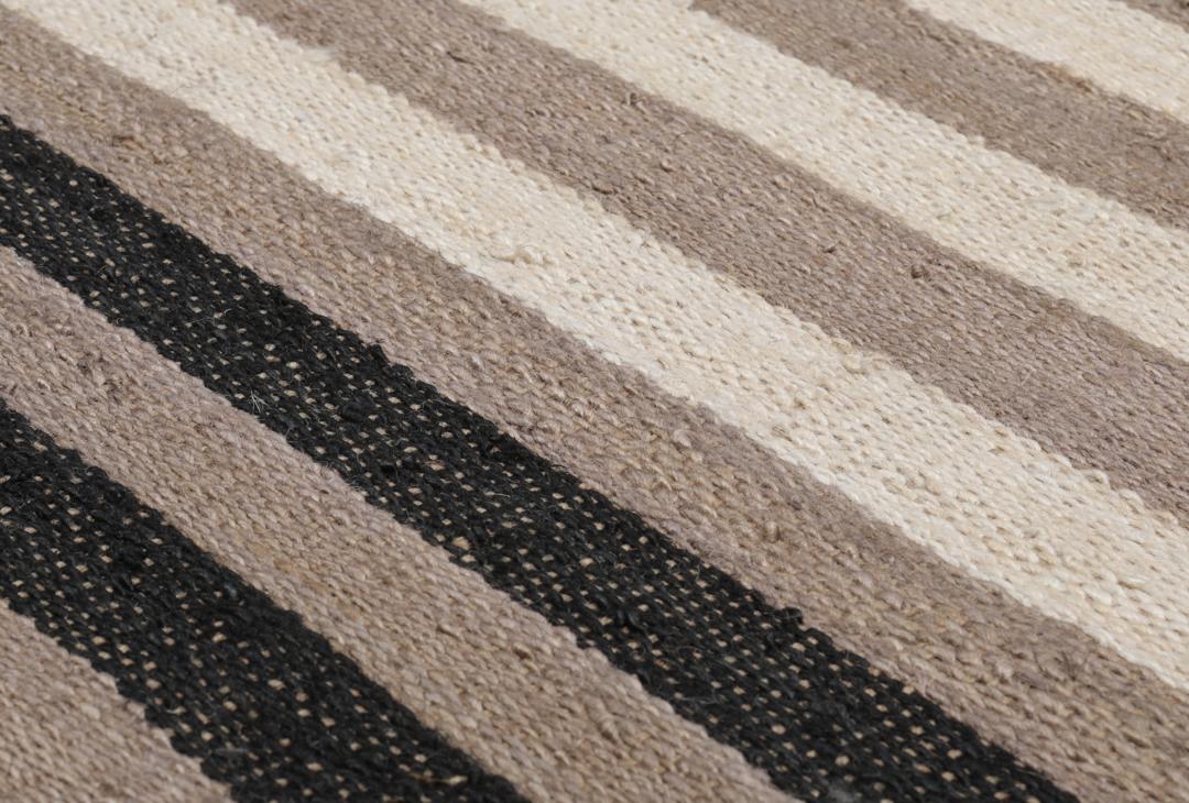 Beige og svart stripete teppe laget av jute.