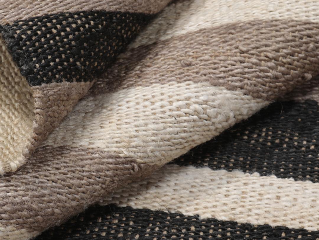 Beige og svart stripete teppe laget av jute.