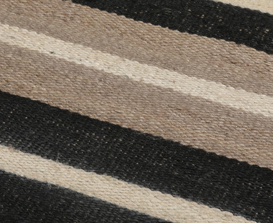 Beige og sort stribet tæppe lavet af jute.