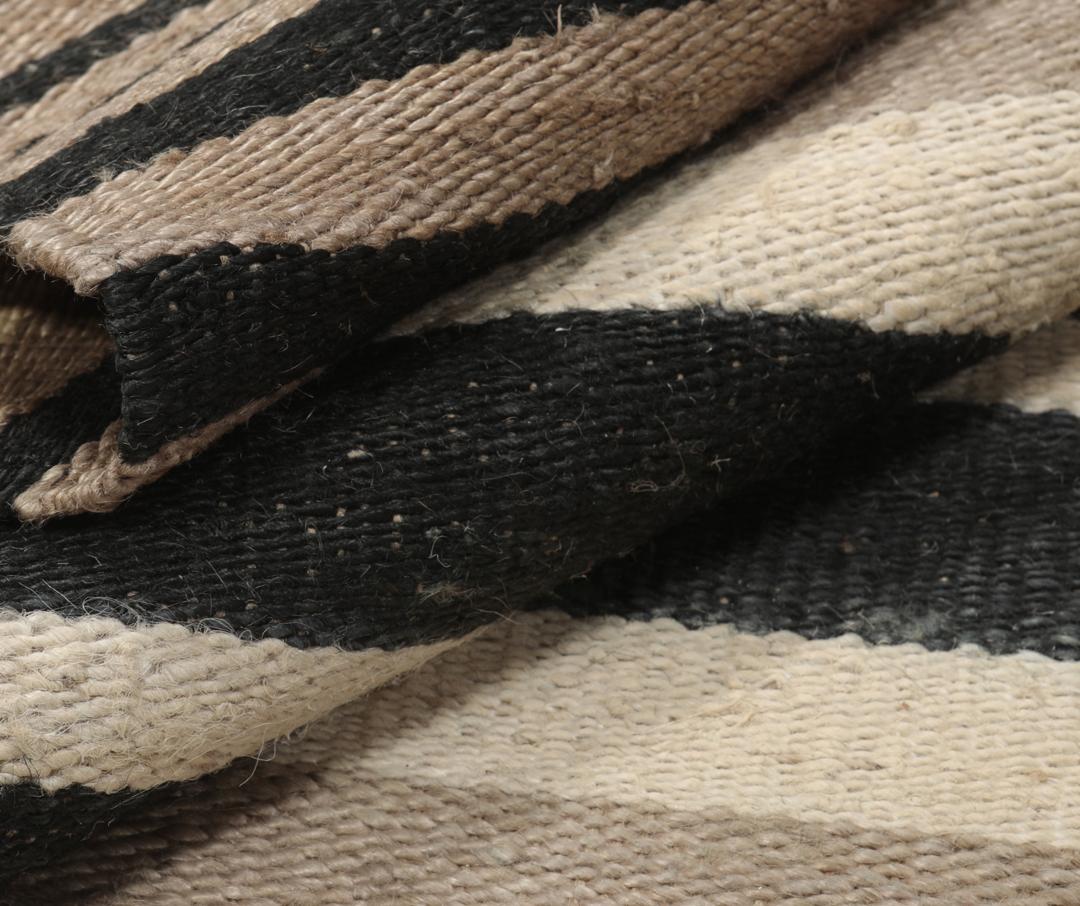 Beige og sort stribet tæppe lavet af jute.