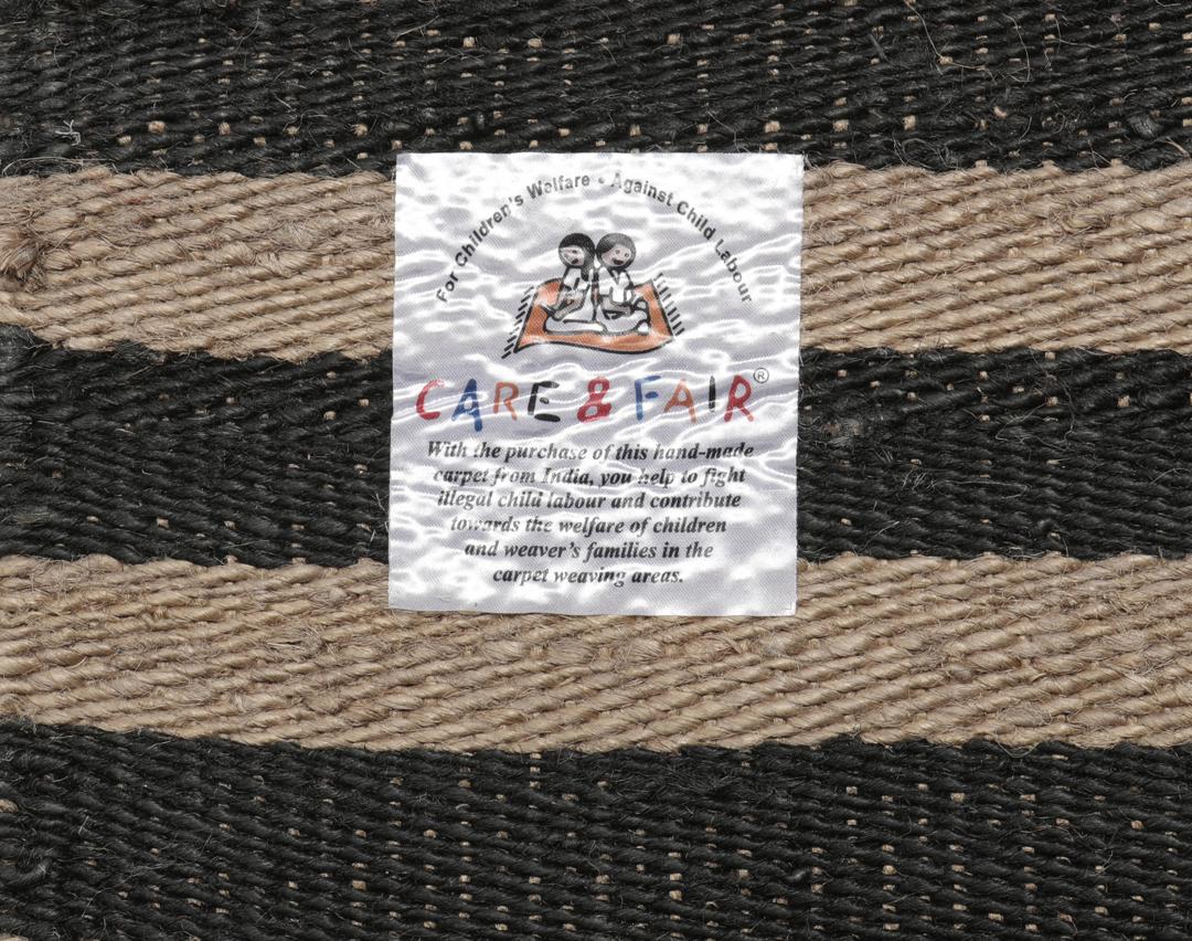 Beige og sort stribet tæppe lavet af jute.