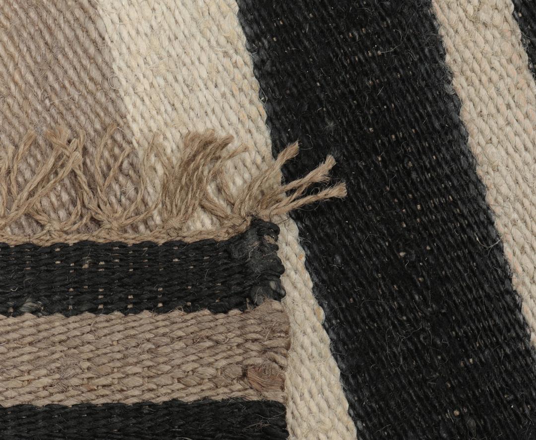 Beige og sort stribet tæppe lavet af jute.