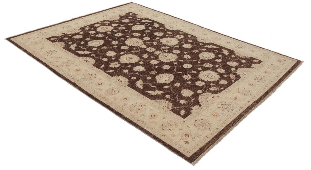 Un tapis Ziegler rectangulaire d'Afghanistan avec un champ marron foncé et des motifs floraux beiges.