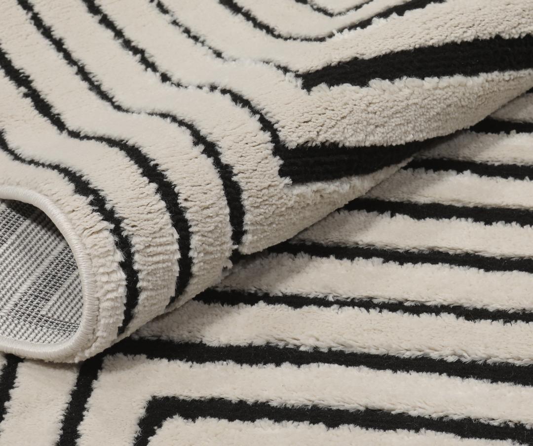 Cream white rug with black geometric lines and fringe